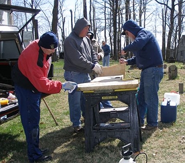 From left to right, Mike Beck, Tim Beckman, and Phil McClure clean and mark a stone for repair